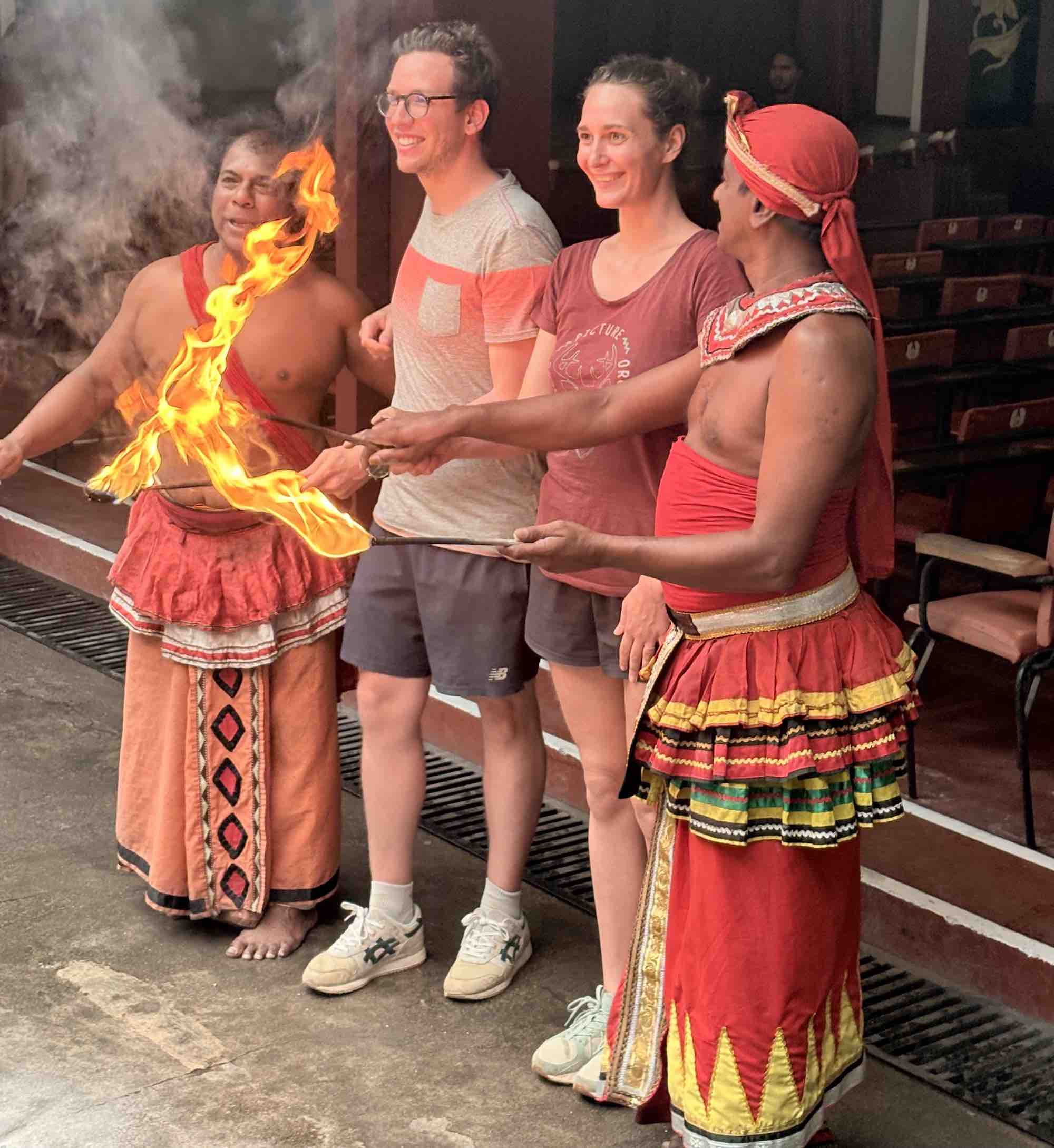 Fire walking performer at the Kandy cultural show with sparks flying off the embers