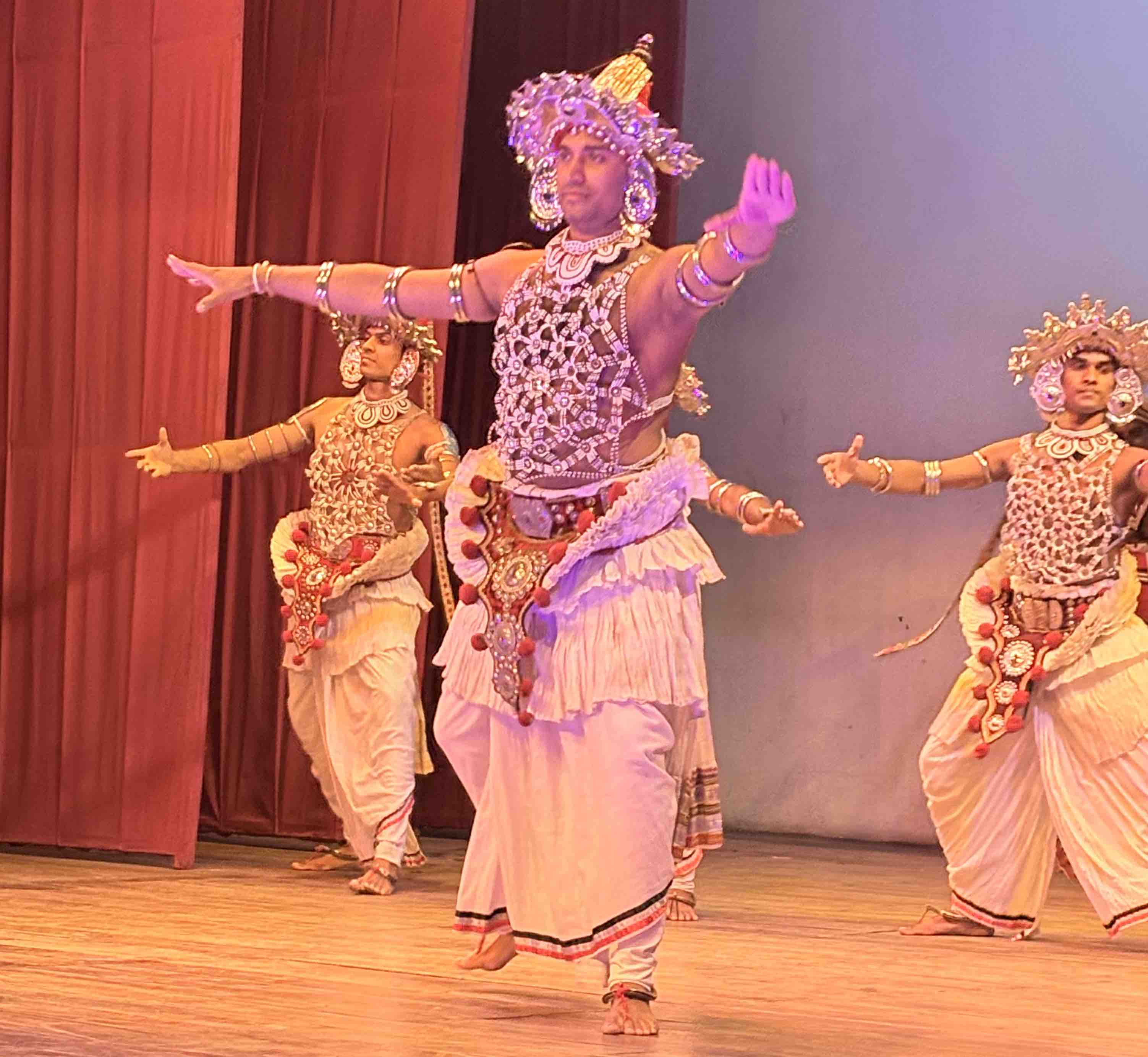 Traditional Kandyan dancers in silver Ves costumes performing at the Kandy Cultural Show