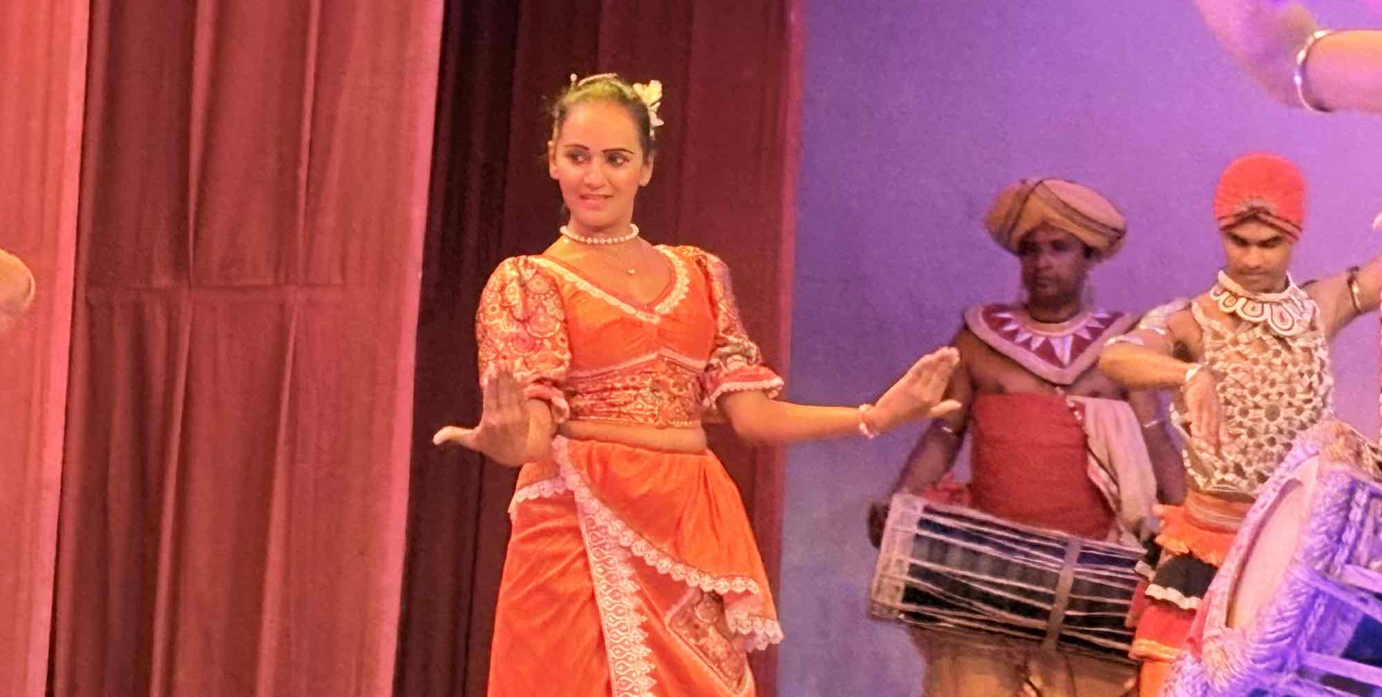 Female Kandyan dancers performing the Pooja Natum offering dance in red and gold costumes